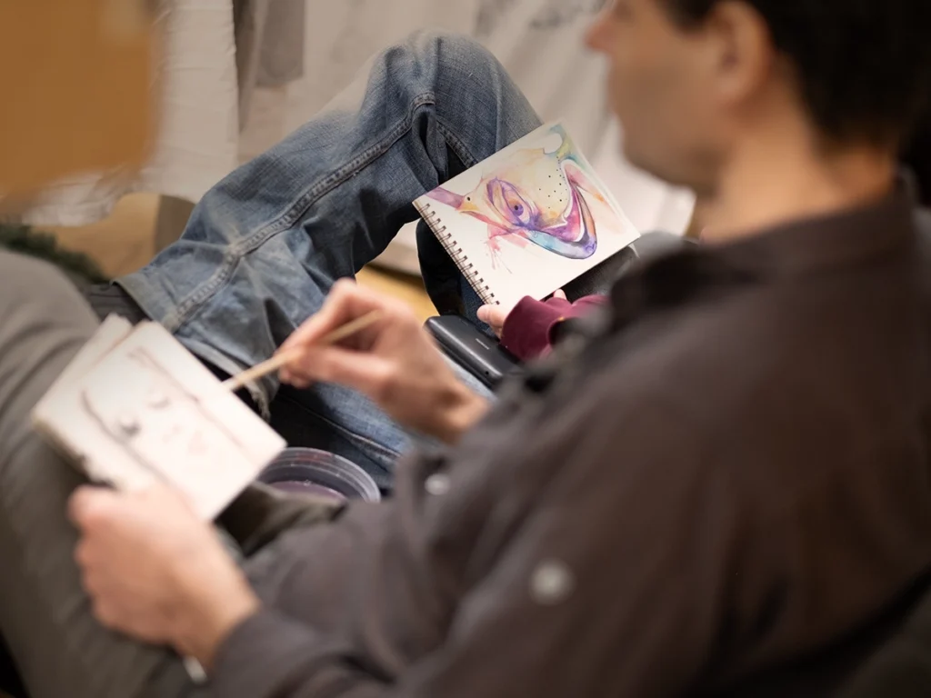 Two people drawing and painting a still life with watercolor.