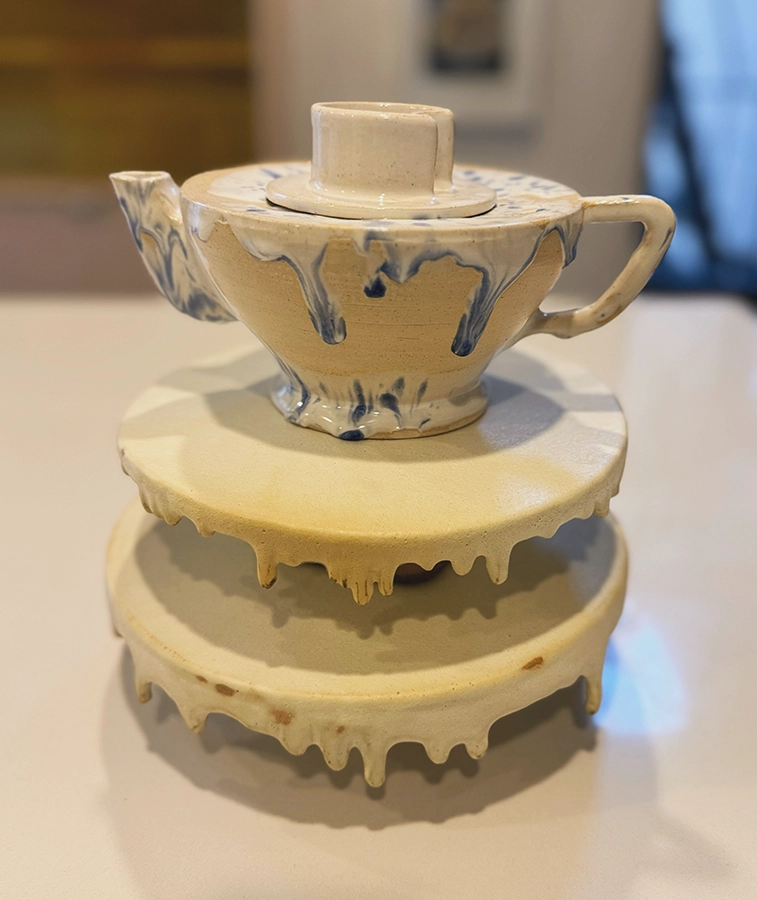 Ceramic teapot and raised plates with dripping clay and glaze surfaces, titled Dripping Tea Party by the author